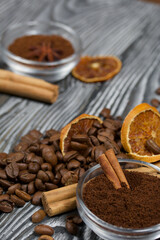 Coffee beans. Ground coffee in containers and spices. On a surface of brushed pine boards painted black and white.