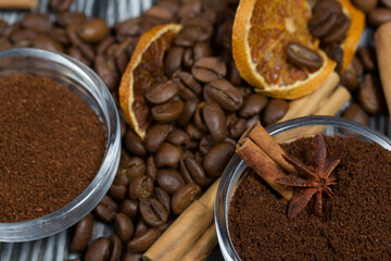 Coffee beans. Ground coffee in containers and spices. On a surface of brushed pine boards painted black and white.