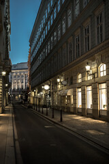 Naklejka na ściany i meble Abandoned Narrow Road With Illuminated Stores In The Inner City Of Vienna In Austria