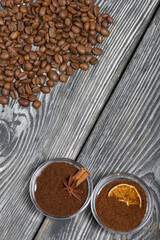 Coffee beans. Ground coffee in containers and spices. On a surface of brushed pine boards painted black and white.