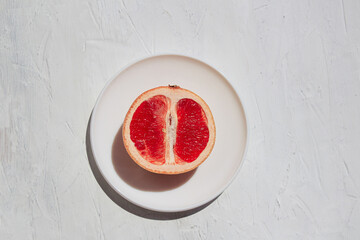 Fresh juicy fruits grapefruit on white plate on white background. Citrus juices