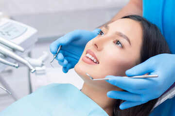 Fototapeta premium Attractive young woman in a dental clinic with a male dentist. Healthy teeth concept.