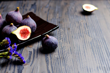 Fresh ripe figs on dark plate, rustic background, closeup, copy space