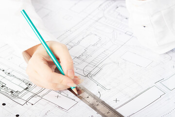 architect designer working on architectural blueprints, building plans in the office, drawing
