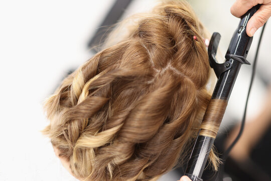 Hair curlers make curls on women's hair. Services of a hairdresser for evening and festive hairstyles concept