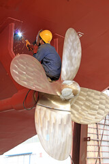 industrial workers welding ship propeller