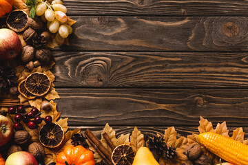 top view of autumnal harvest and foliage on brown wooden background