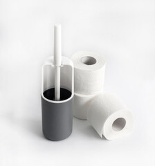 White and gray plastic toilet brush and roll of toilet paper on white background