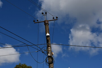 Electric pole with wires on the background of the sky and clouds. Such structures are located in...