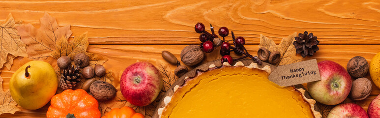 Top view of thanksgiving pumpkin pie with autumnal decoration on wooden background, panoramic shot