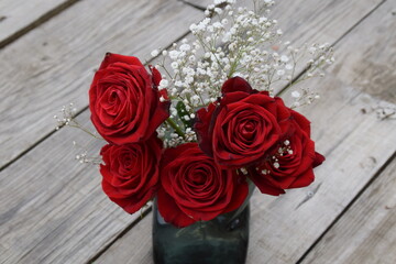 Ramo de rosas rojas con fondo de maderas