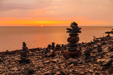 Beautiful stone pyramid built from pieces of rocky shore of Baltic sea. Sunset time.