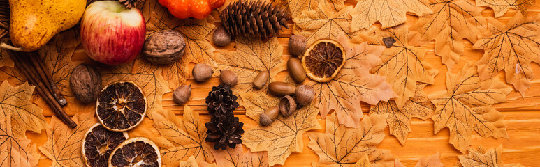 top view of autumnal decoration and food on golden foliage on wooden background, panoramic shot