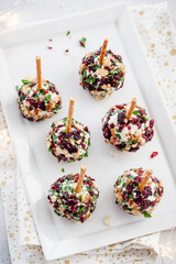 Christmas cheese ball appetizers with cranberries, pecans and herbs.