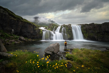 Waterfall in iceland with woman watching