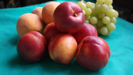 Nectarines, peaches, green grapes close-up.