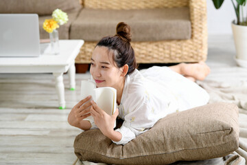 寝転びながら読書をする若い女性