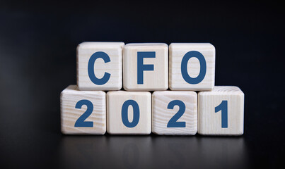 CFO 2021 text on wooden cubes on a black background with reflection.