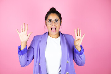 Young beautiful business woman over isolated pink background showing and pointing up with fingers number nine while smiling confident and happy
