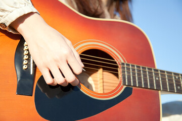ギターを弾く女性の手元