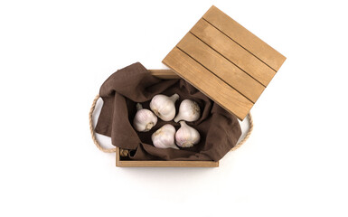 White garlic isolated on a white background, side view, in a wooden box. Full frame. Plant background. The concept of food and agricultural products.