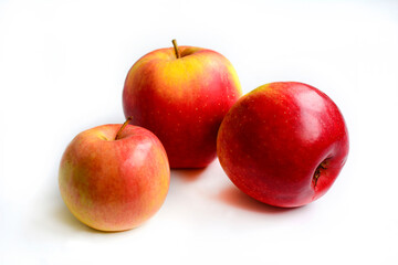 Three ripe juicy red apples on a white background