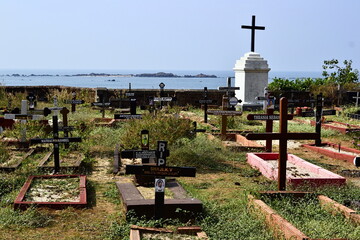 Kerala, India - January, 2017: Old historical catholic cemetery. Graves with cross on the coast behind the colonial church near Thalassery Fort