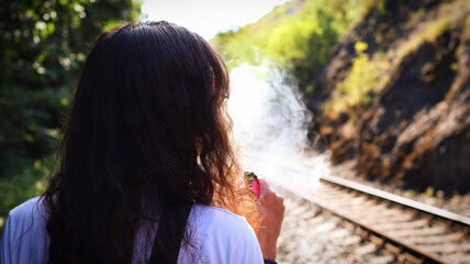Young woman exhales smoke