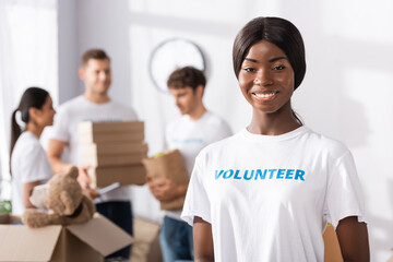 Selective focus of african american volunteer looking at camera in charity center