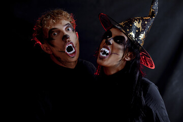 Halloween loving couple with skull makeup looking at each other, view of faces. Halloween or horror...