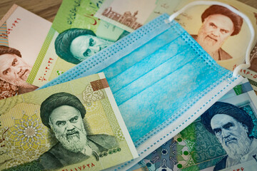 Iranian currency, anti-virus mask. The concept of the country's economy during the coronavirus pandemic