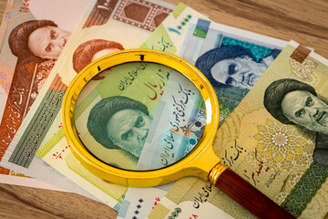 Iranian currency, Rials, Various paper banknotes under a magnifying glass, Country economy concept