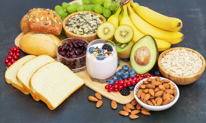 Group Fruits Breakfast with bread Whole grains and nuts, yogurt mix with Cherry , banana, avocado in the wooden table. Breakfast for Health and Diet concept