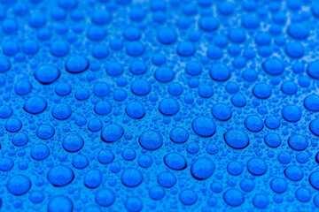 water drops on the hood of a blue car. 