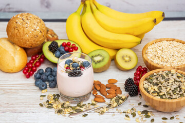 Group Fruits Breakfast with bread Whole grains and nuts, yogurt mix with Cherry , banana, avocado in the wooden table. Breakfast for Health and Diet concept