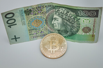 moneta bitcoin na tle waluty polskiej złotówki