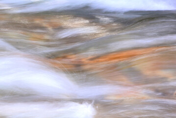 Colorful abstract patterns produced by frozen movement of rushing water in stream. Possible background image.