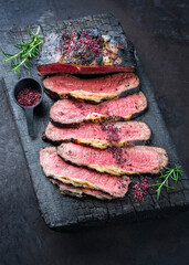 Traditional Commonwealth Sunday roast with sliced cold cuts roast beef with herbs and salt as top...