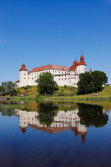The medieval Lacko castle located in the Swedish province of Vastergotlande is reflected in lake Vanern.