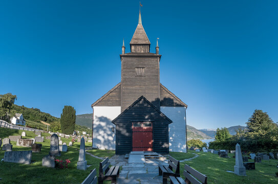 Leikanger Church, Leikanger village, on the northern coast of the Sognefjorden. Sogndal, Vestland. Norway. Built in 1250. White, stone  with a a large wooden steeple.