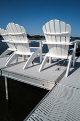 Fototapeta premium empty white chairs along the waterfront dock 