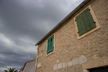 Fototapeta na wymiar Old, stone house with gren shutters in oldest town on the Hvar island- Stari Grad