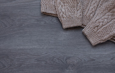 Knitted warm sweaters on wooden table.