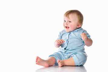 Fototapeta premium Little boy in a pajama bodysuit is playing in the studio on a white background.