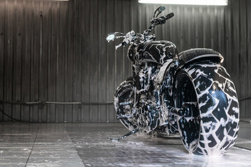 Wet and soapy black motorcycle at the car wash