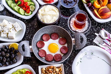 Traditional Turkish Breakfast with sausage egg pan on marble table.Close up taken             