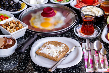 Traditional Turkish Breakfast with sausage egg pan on granite marble table.Close and large view.               