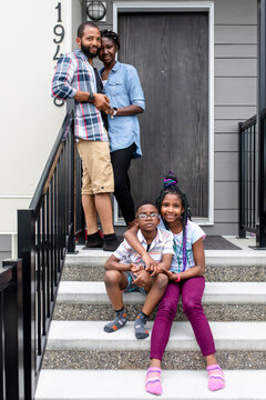 Portrait happy affectionate family on front stoop
