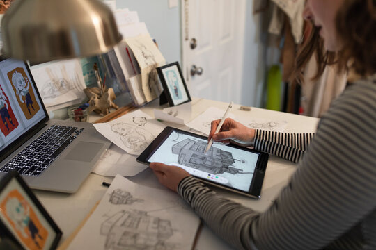 Young female artist drawing with digital tablet