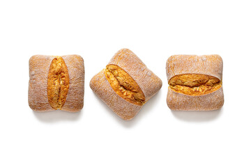 Three small italian ciabatta breads, with a cut on a golden crust on a white